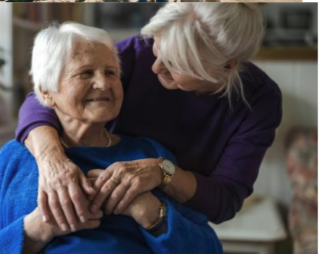 Caregiver comforting an older woman at home